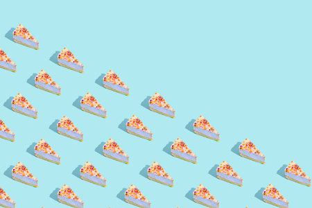 Creative pattern made of piece of cheesecake on pastel blue background. Festive and party concept....
