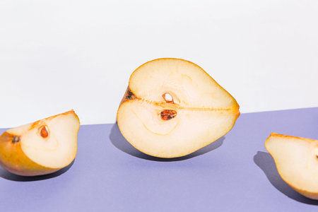 Creative layout made of raw sliced pears on white and violet background. minimal style. Healthy food ingredient concept. still life compositionの写真素材