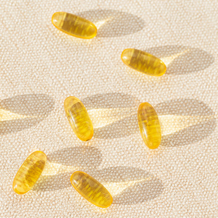 Pills of omega 3 close up on pastel background with shadow. health care concept. Supplements and...