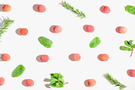Fresh lychee fruits with rosemary and mint leaves on white background. Minimal style composition....