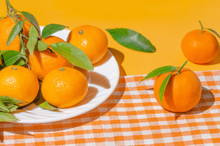 Creative still life composition made of fresh orange tangerin fruits on a white plate. Healthy food concept. Summer refreshment theme.の写真素材