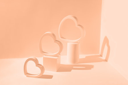 Creative composition made of heart shaped figures and geometric podiums on sunlit background with shadows. Valentine day and romance concept. Color of the year 2024 inspiredの写真素材