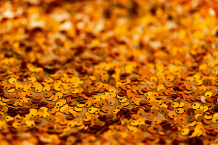 Abstract composition of fabric with shiny sequins. Holiday and party concept. Warm yellow, orange and brown colorsの写真素材
