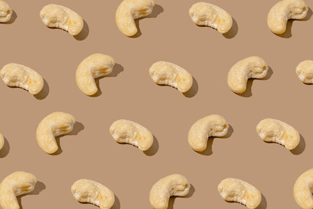Creative pattern made with cashew nuts on beige background. Healthy food ingredient concept.Minimal style. flat lay. Top viewの写真素材