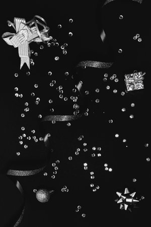 Silver holiday accessories on a black background. Party and celebration concept. Top view. Flat lay