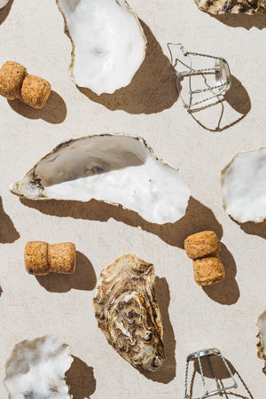 Creative composition made of oyster shells, champagne corks and metal wire muselet on pastel sunlit background with shadow. Party concept. Top viewの写真素材