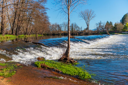 Waterfall on the river in the city park. Spring scenery.の写真素材