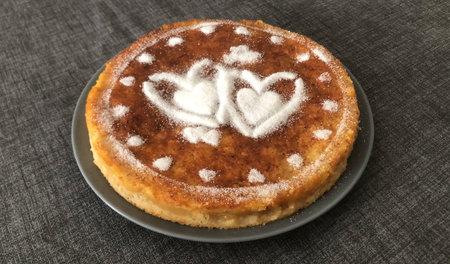 Delicious homemade cake with sugar powder and hearts on a gray backgroundの写真素材