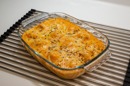 Baked lasagna with cheese and herbs in a glass baking dishの写真素材
