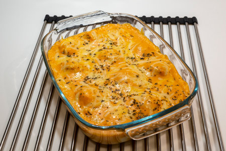baked lasagna with cheese and herbs in a glass baking dishの写真素材
