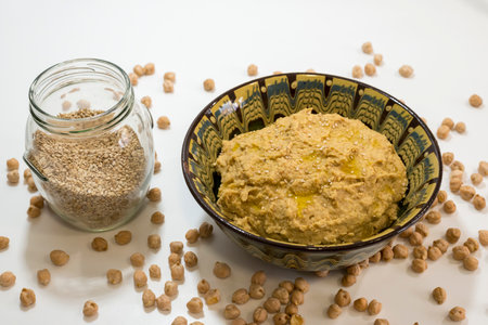 Bowl of chickpea hummus with chickpeas on white backgroundの写真素材