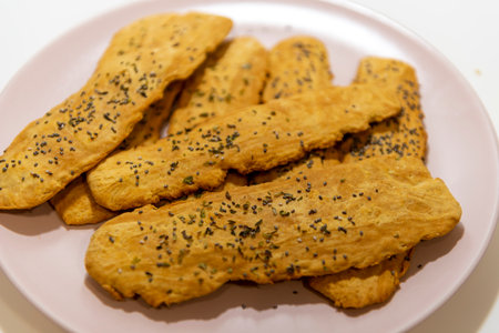 Sesame cookies on a white plate with black sesame seeds.の写真素材