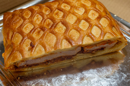 Baked pie with meat and cheese on a baking sheet close upの写真素材