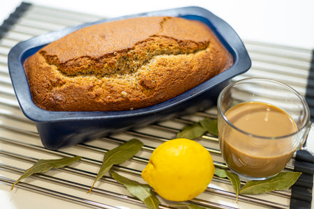Homemade lemon pound cake in blue baking dish with a cup of coffeeの写真素材