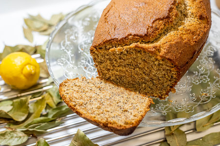 Freshly baked homemade lemon cake with whole and sliced lemons and bay leaves.の写真素材