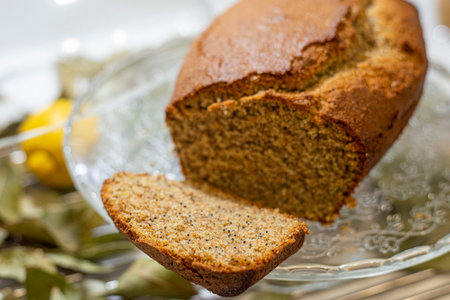 Freshly baked homemade cake with poppy seeds on a glass plate.の写真素材