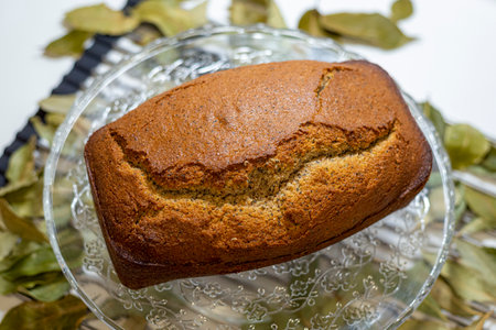 Freshly baked homemade banana bread on a glass plate with bay leafの写真素材