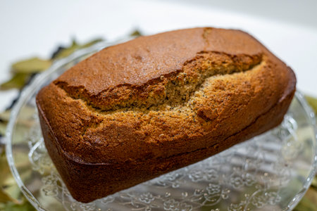 Freshly baked homemade banana bread on a glass plate with bay leavesの写真素材
