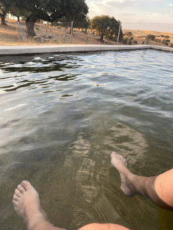 Man's feet in the water of a lake on a sunny dayの写真素材