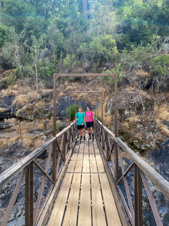 Senior couple walking on the wooden bridge over the river in the forestの写真素材