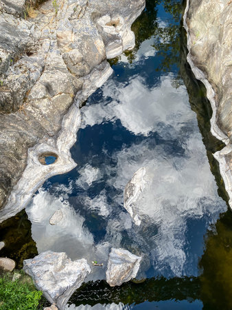 Water flowing through rocks in the river, closeup of photo.