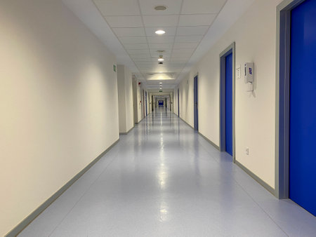 Interior of a hospital corridor with blue walls and white floor.の写真素材