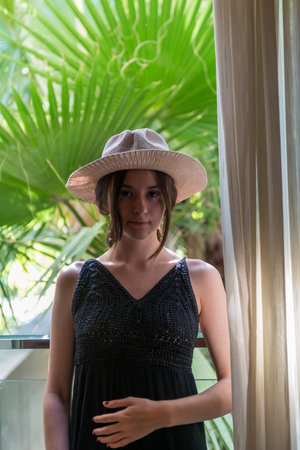 Portrait of a beautiful young girl in a hat and black dress Spanish brunette woman European womanの写真素材