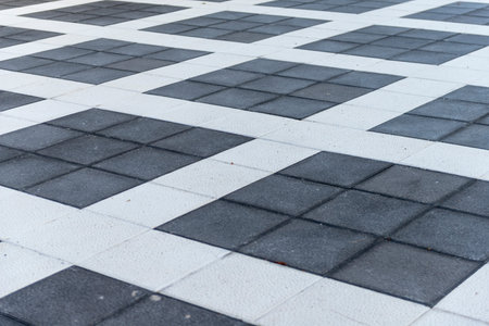 White and gray ceramic tile floor pattern in public park, stock photo