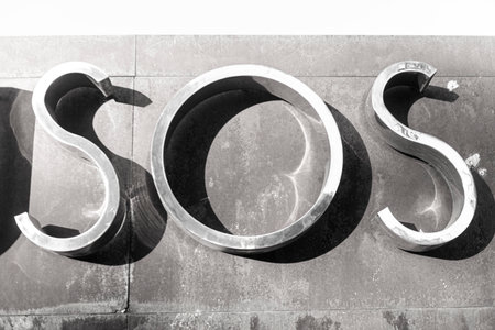 SOS sign on the wall of a building, closeup of photoの写真素材