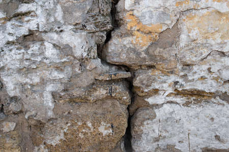 A crack in the old stone wall backgroundの写真素材