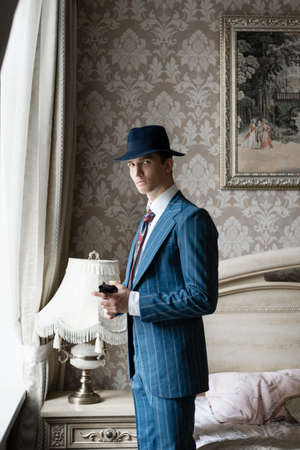 A young man in a business suit is holding a gun in his handsの写真素材