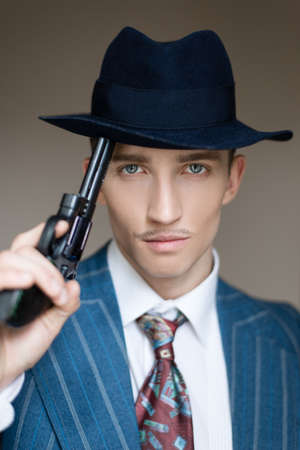 Portrait of a man in a business suit holding a gun in his handsの写真素材
