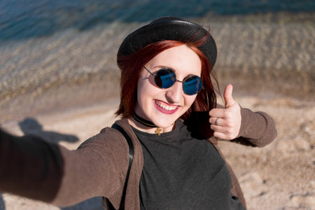 Girl on the seashore thumb lifted up
