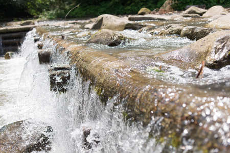 Small falls, under which visible huge sticks and stonesの写真素材