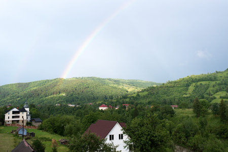 Over the wood and houses the rainbow is seenの写真素材