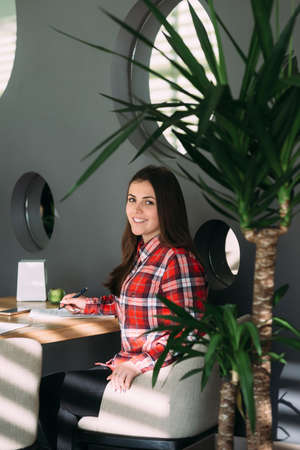 portrait of a girl in a cafe she is young with black long hairの写真素材
