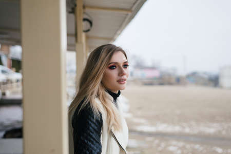 very beautiful blonde is standing alone on the beach, looking into the distance and thinking about somethingの写真素材