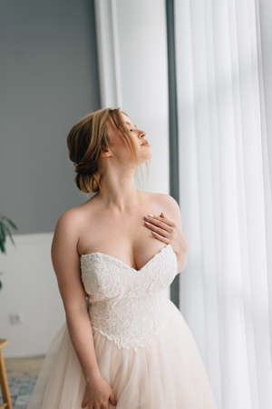 Wedding portrait of a bride with a big bust in a beautiful white fluffy dressの写真素材
