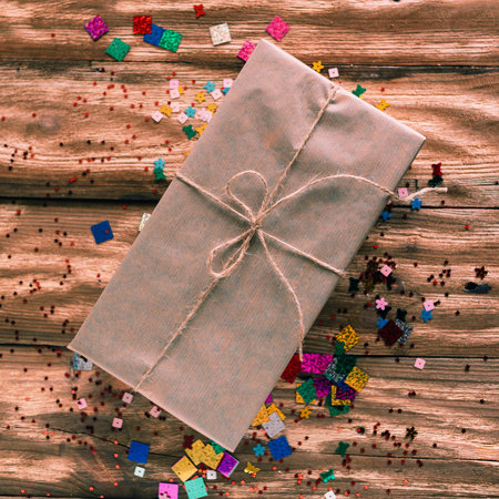 a holiday box with a gift is on the table and around the candyの写真素材