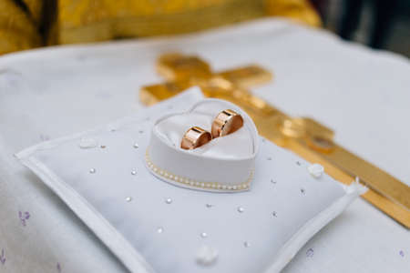 Wedding rings lie on the pillow next to each otherの写真素材