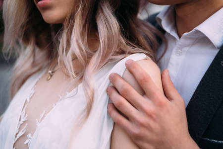 outdoor wedding ceremony in nature. The groom gently strokes the bride. Stylish couple bride and groomの写真素材