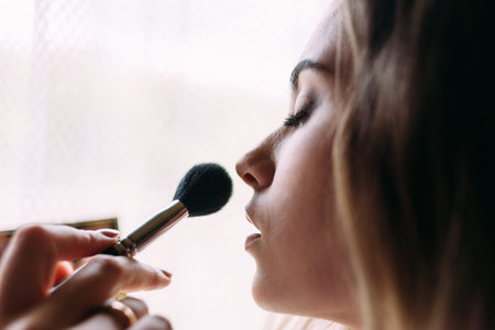 makeup artist makes wedding makeup to the bride. portrait photo of the bride. On the face of the...