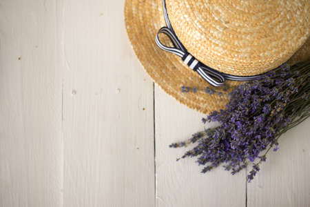 on a white table in the corner is a straw hat with a field bouquet of lavender flowers. aromatherapy for sleep.の写真素材