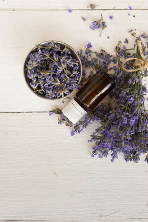 on wooden background set for spa treatments lavender bouquet for the bathroom aromatherapy oil for massage. natural products.の写真素材