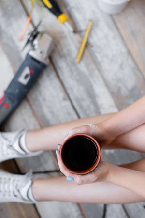 a cup of coffee in the hands of the girl. Close-up photo tools for robots. lunch break.の写真素材