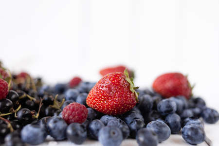 ripe berries strawberries, blueberries, raspberries and currants on a white table. Delicious summer berries. Fragrant berries on the tableの写真素材