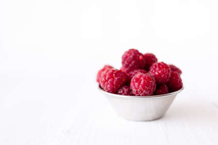 Ripe raspberries on white background. nutritious and healthy breakfast. Source of vitamins and mineralsの写真素材