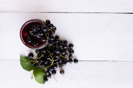 source of vitamins and minerals, black currants on a jar of jam. Wood tableの写真素材