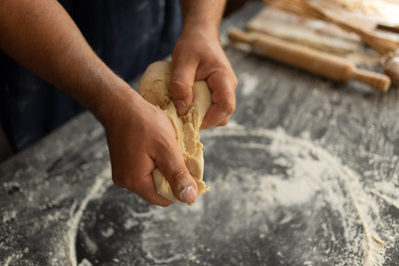 the chef with his strong hands tears off a piece of dough. The process of making pastry. Delicious...