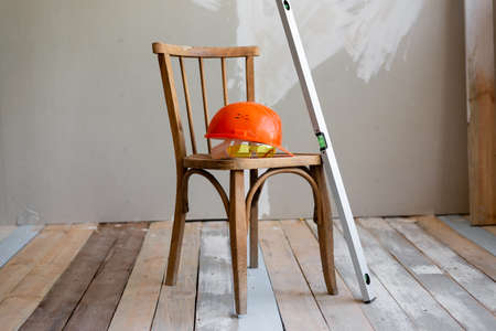 on a wooden table lies a construction helmet level goggles. start of repair in the apartment.の写真素材